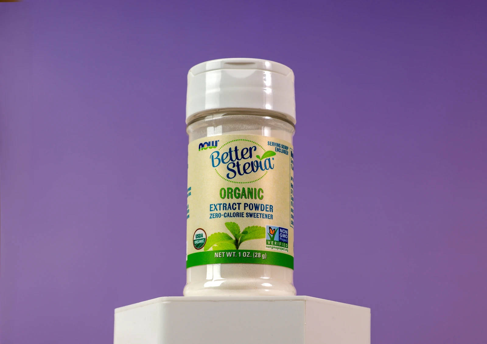 NOW BetterStevia organic sweetener on a white pedestal against a purple backdrop