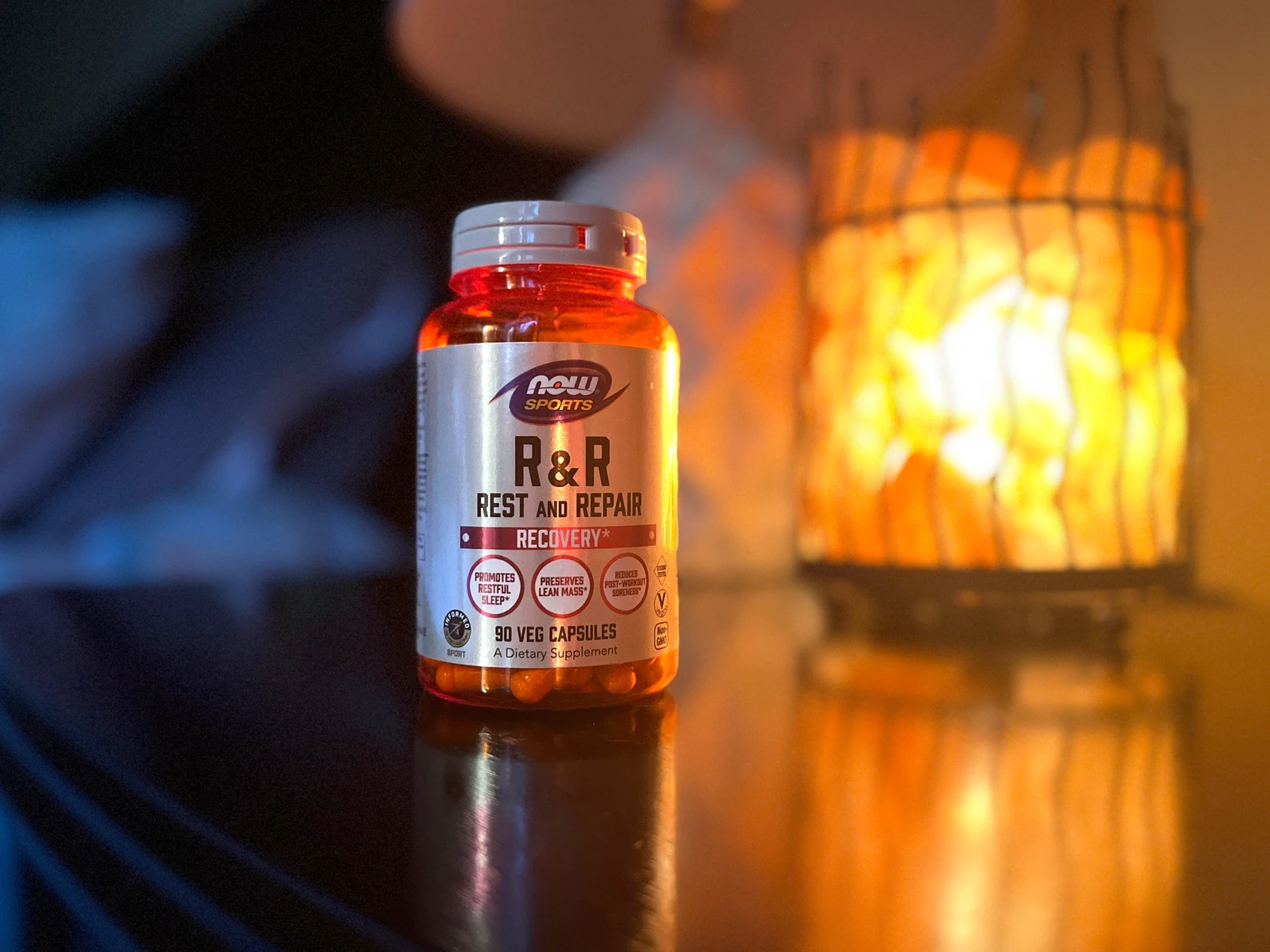 NOW Sports R&R Rest & Repair recovery capsules lit by the glow of a salt lamp