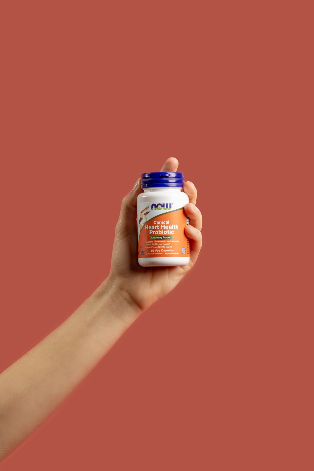 A bottle of NOW Calcium D-Glucarate with a single capsule on a wood table